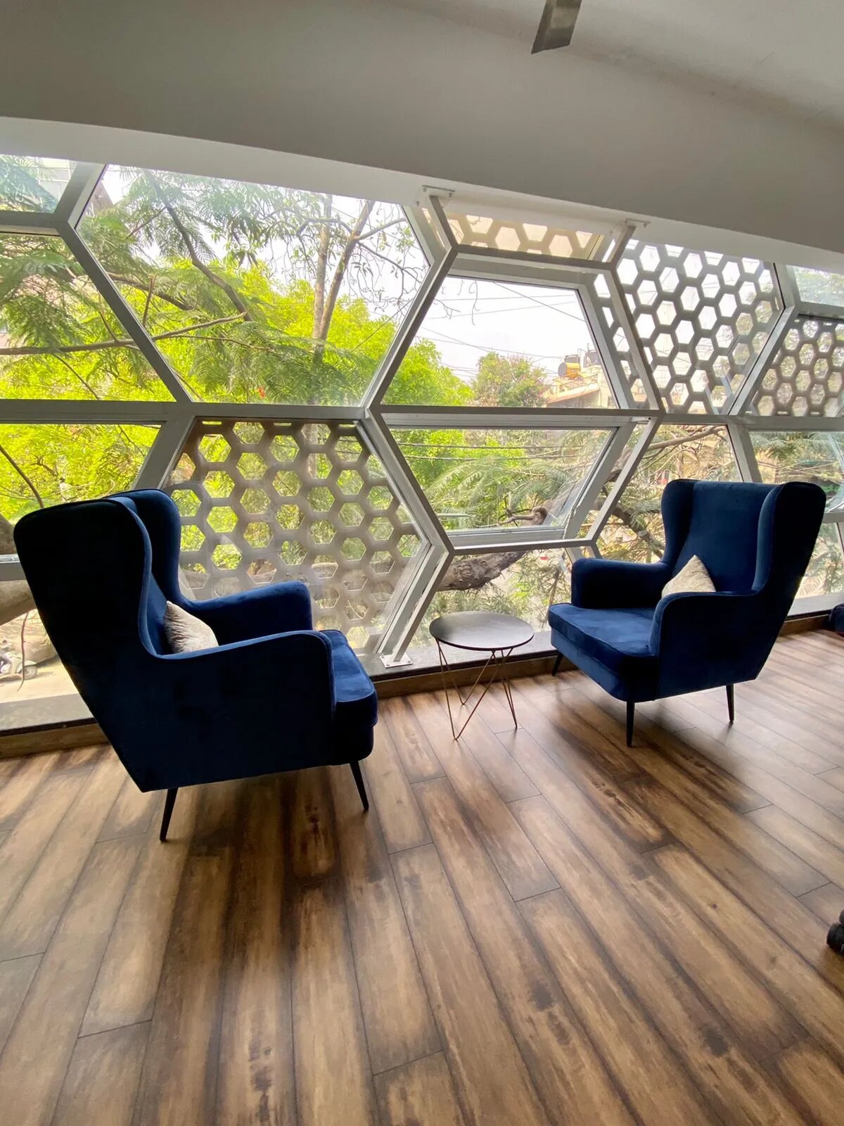 A lounge with hexagonal glazing and velvet armchairs at Dongle Desk
